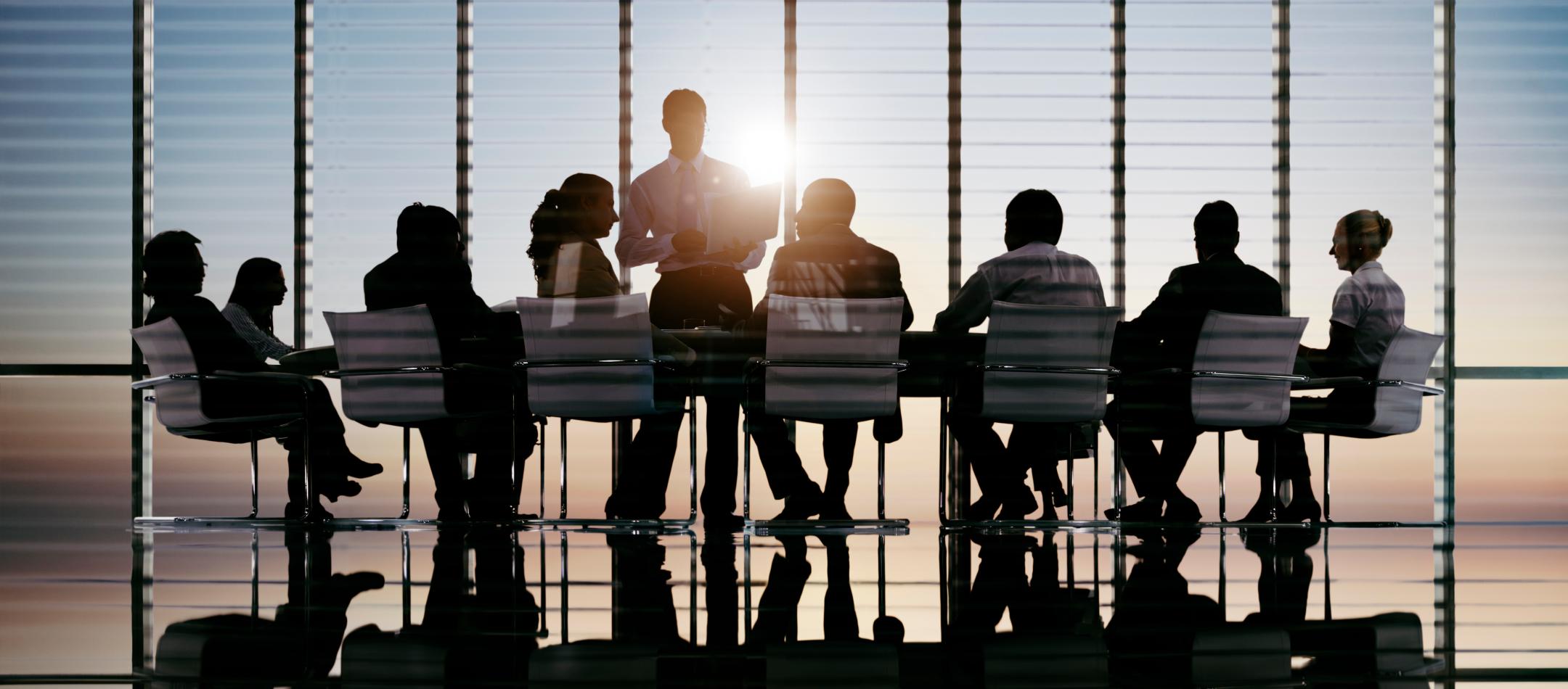 Team members sitting around long conference table